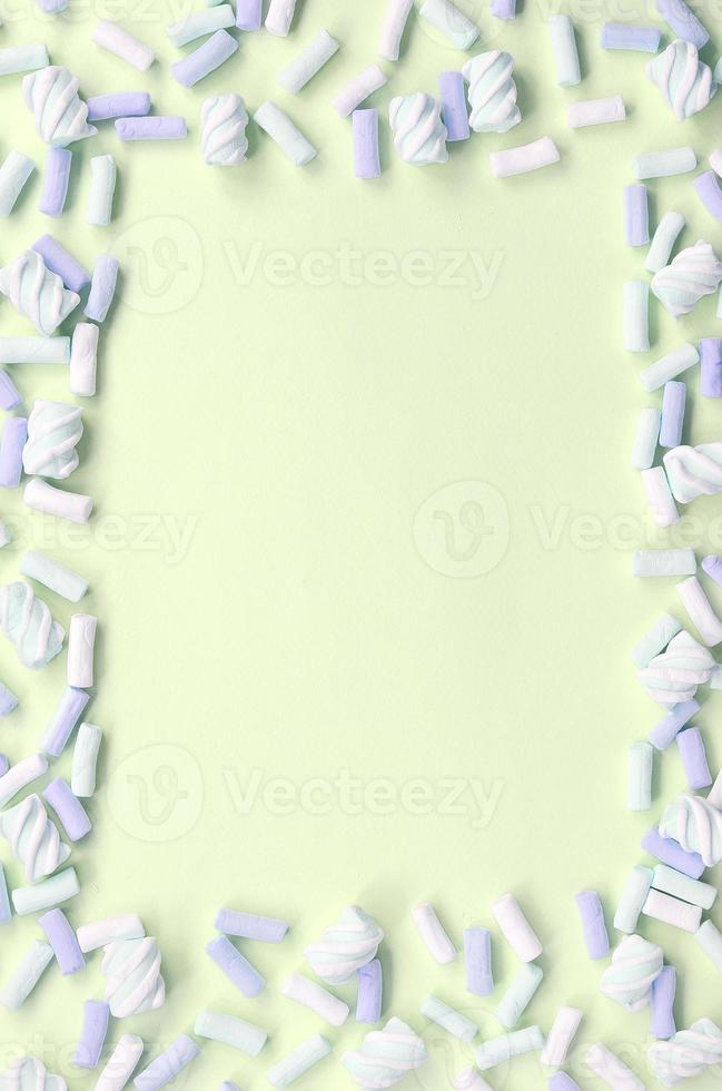 Colorful marshmallow laid out on lime paper background. pastel creative textured framework photo