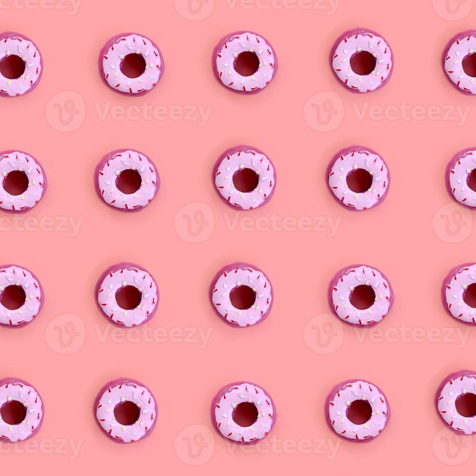 Many small plastic donuts lies on a pastel colorful background. Flat lay minimal pattern. Top view photo