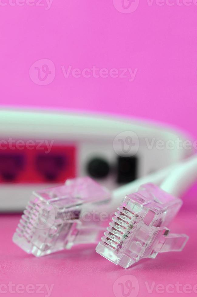 Internet router and Internet cable plugs lie on a bright pink background. Items required for Internet photo