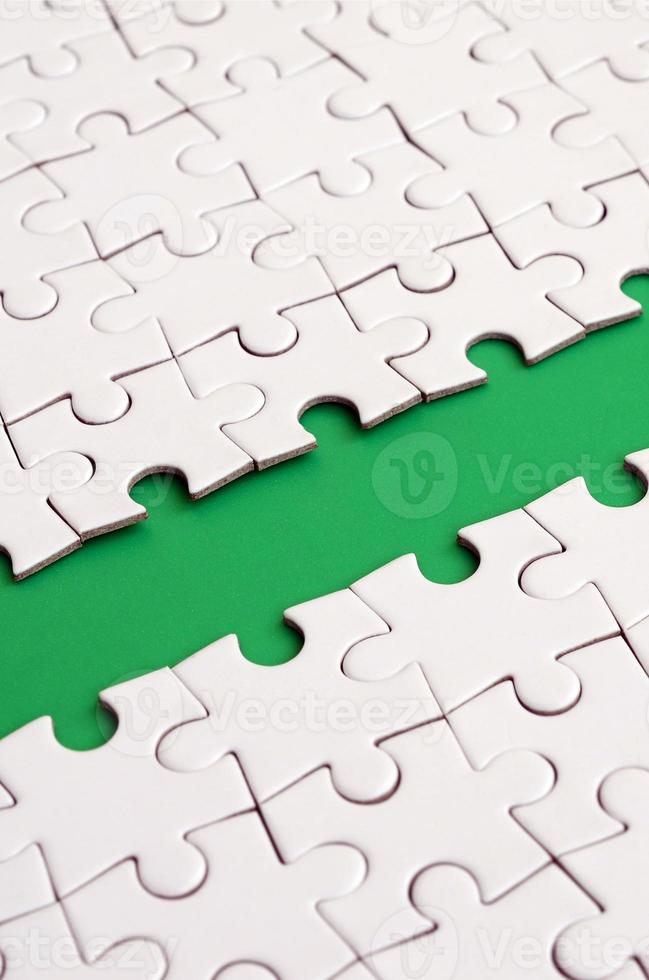 The green path is laid on the platform of a white folded jigsaw puzzle. Texture image with copy space for text photo