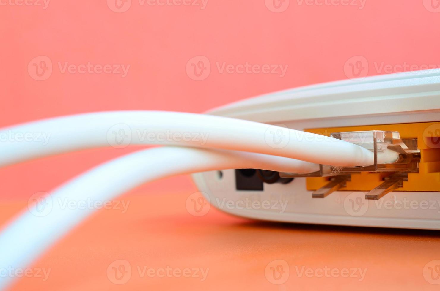 The Internet cable plugs are connected to the Internet router, which lies on a bright orange background. Items required for Internet connection photo