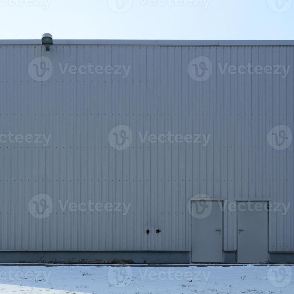 textura de una pared metálica alta de un edificio industrial sin ventanas foto