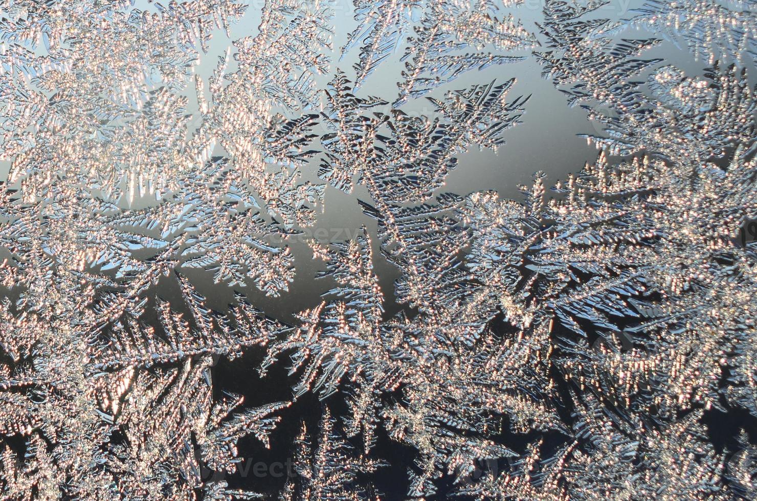 Snowflakes frost rime macro on window glass pane photo