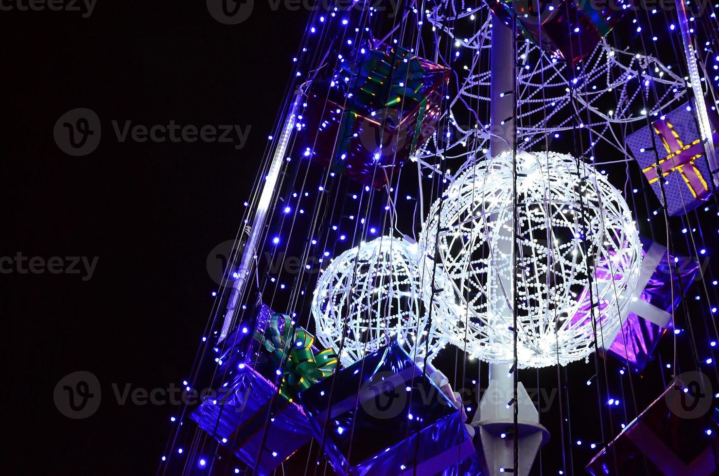 Fragment of the New Year tree. A lot of round lights of blue color are located on a conical frame photo
