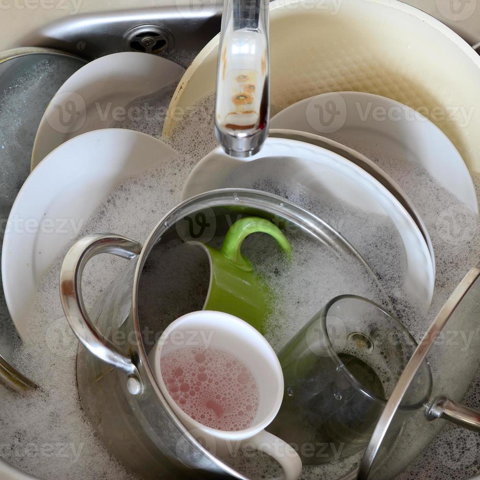 Dirty dishes and unwashed kitchen appliances filled the kitchen sink photo