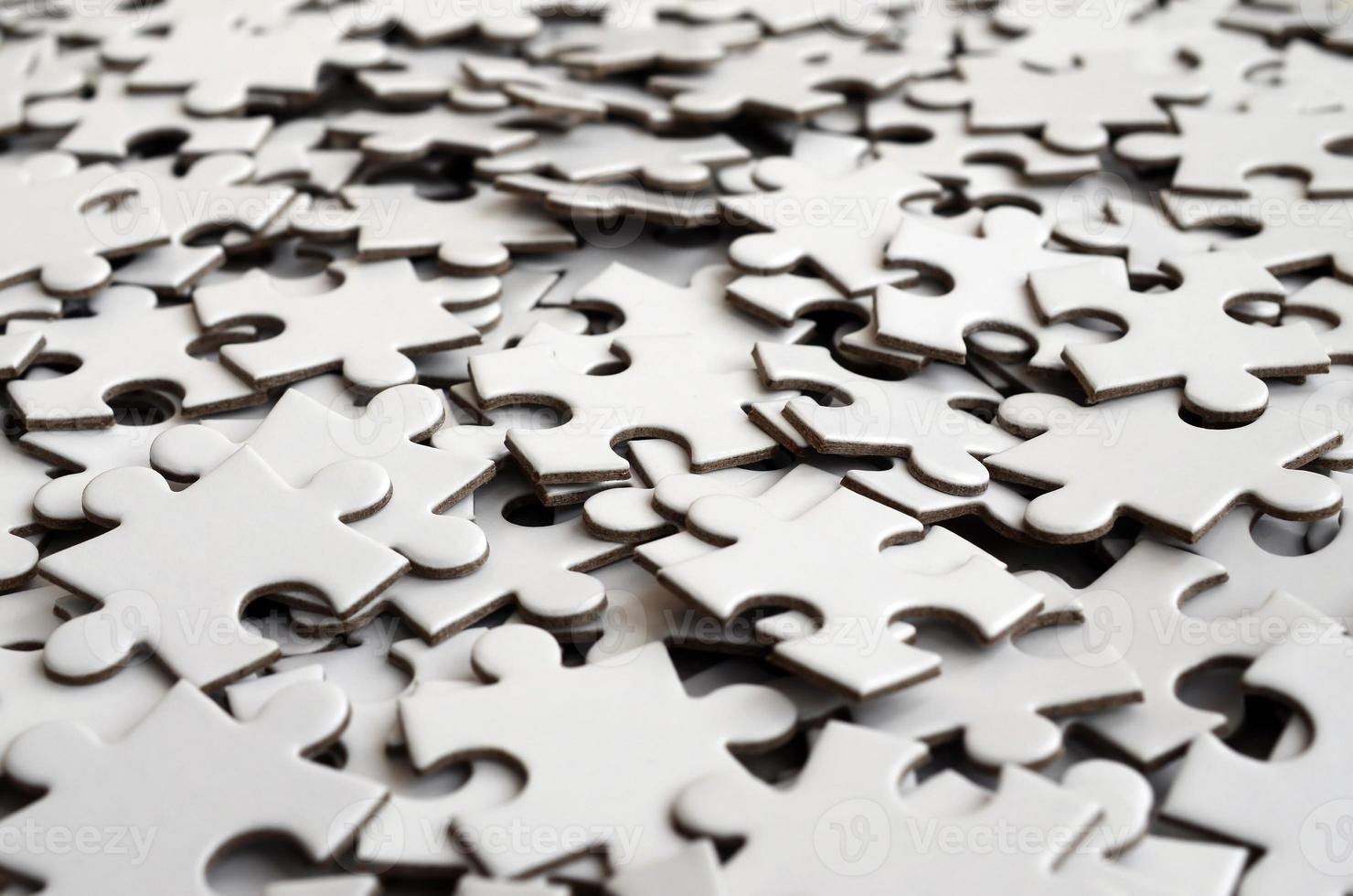 Close-up of a pile of uncompleted elements of a white puzzle. A huge number of rectangular pieces from one large white mosaic photo