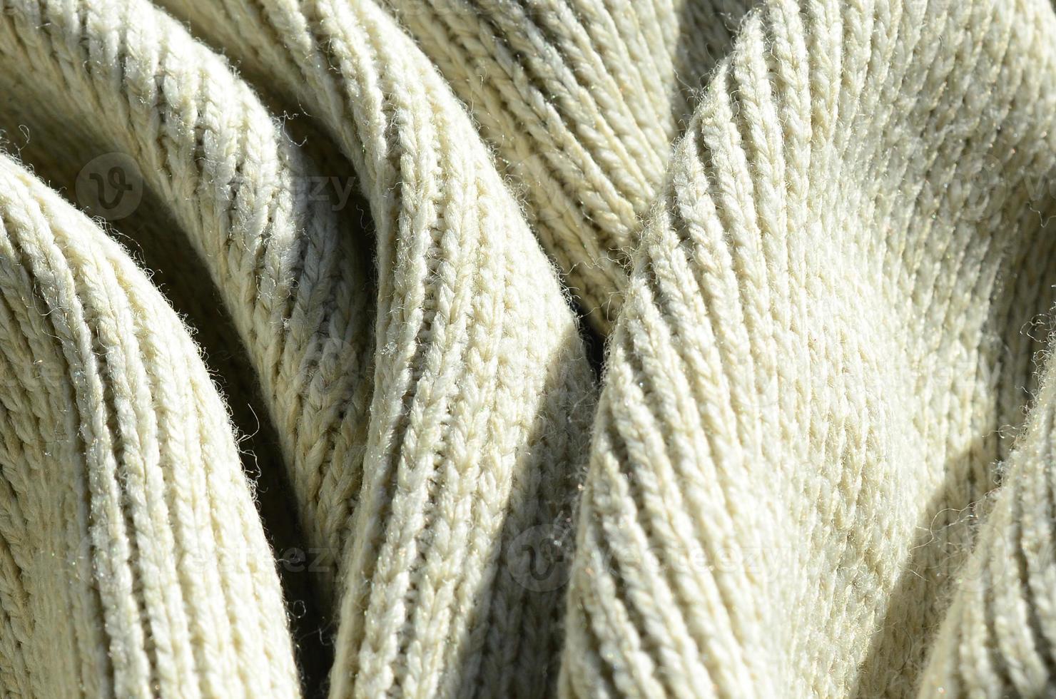 Fabric texture of a soft yellow knitted sweater. Macro image of the structure of bindings in yarns photo