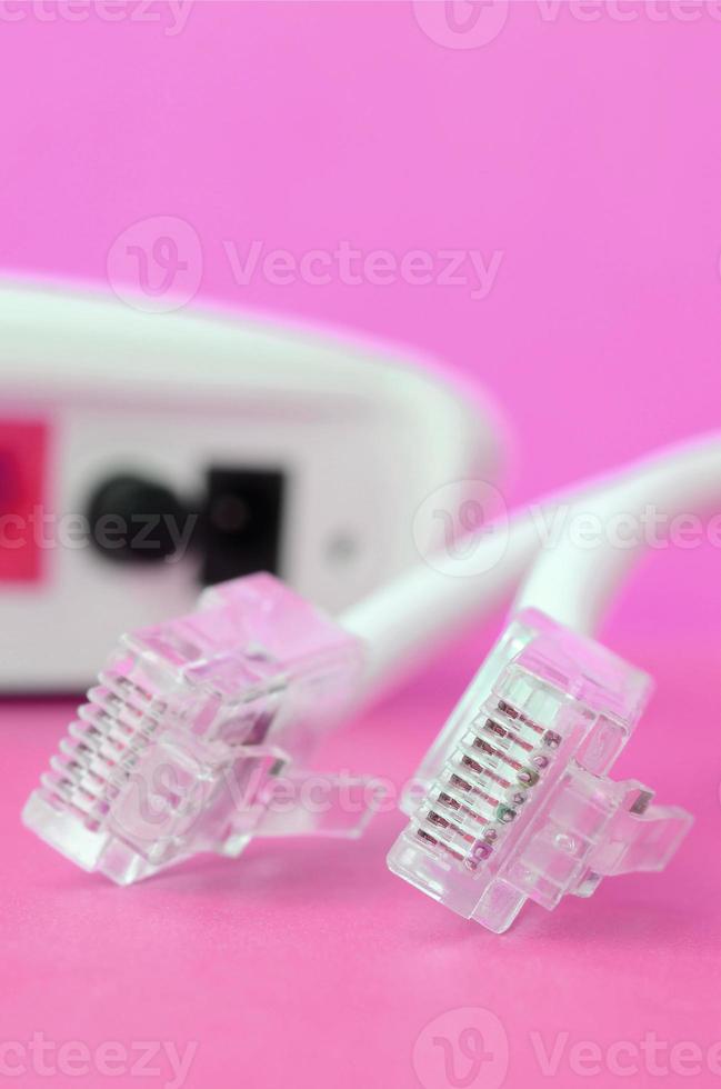 Internet router and Internet cable plugs lie on a bright pink background. Items required for Internet photo