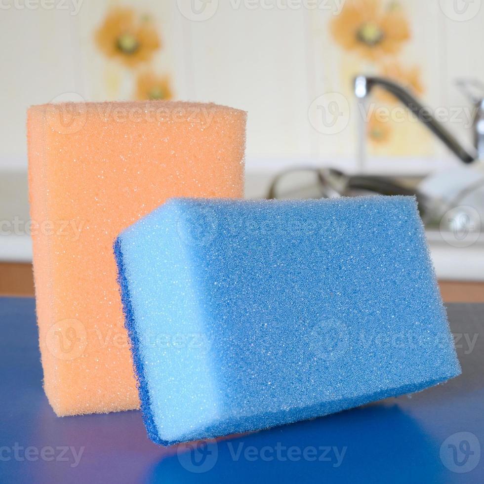 A few sponges lie on the background of the sink with dirty dishes photo