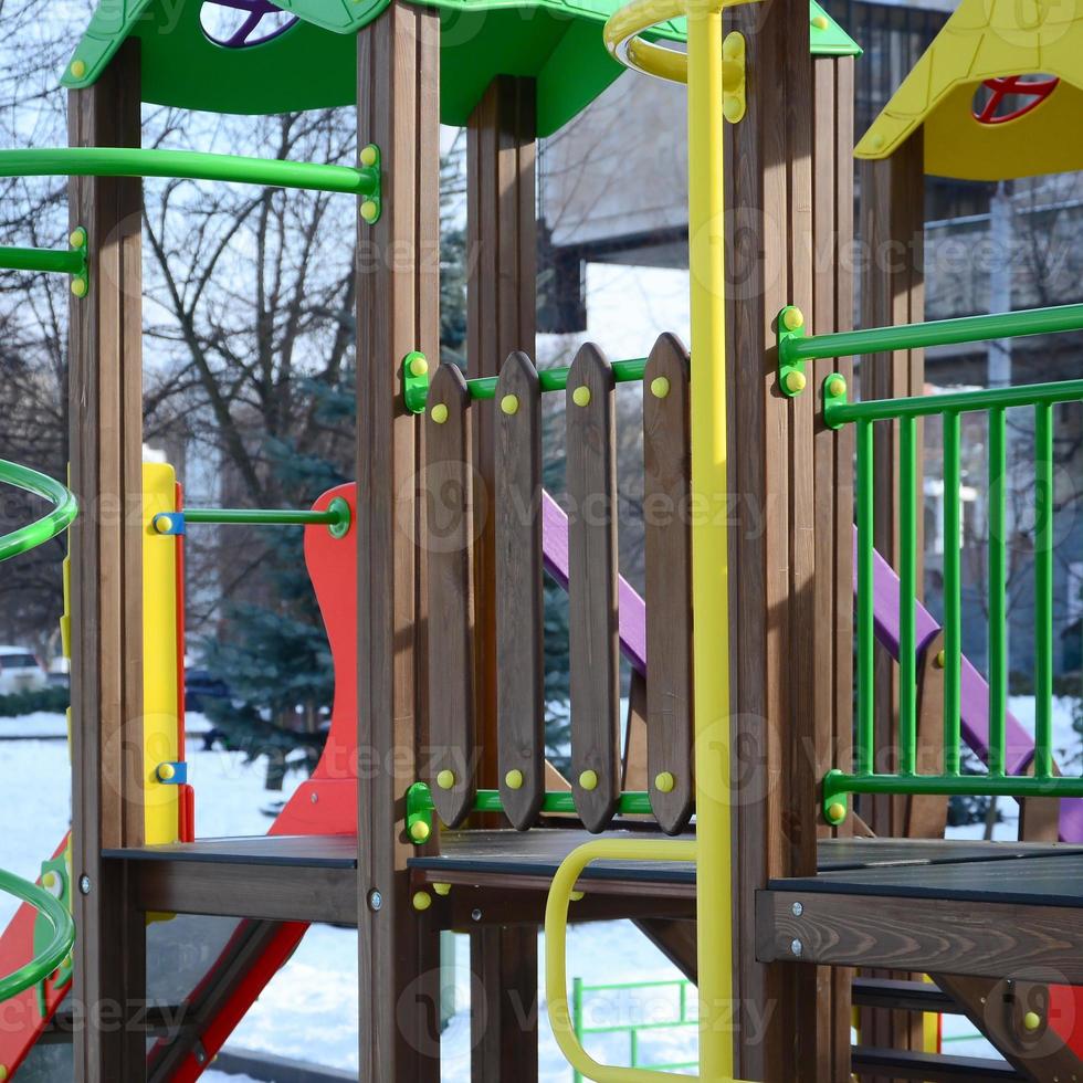 Fragment of a playground made of plastic and wood, painted in different colors photo