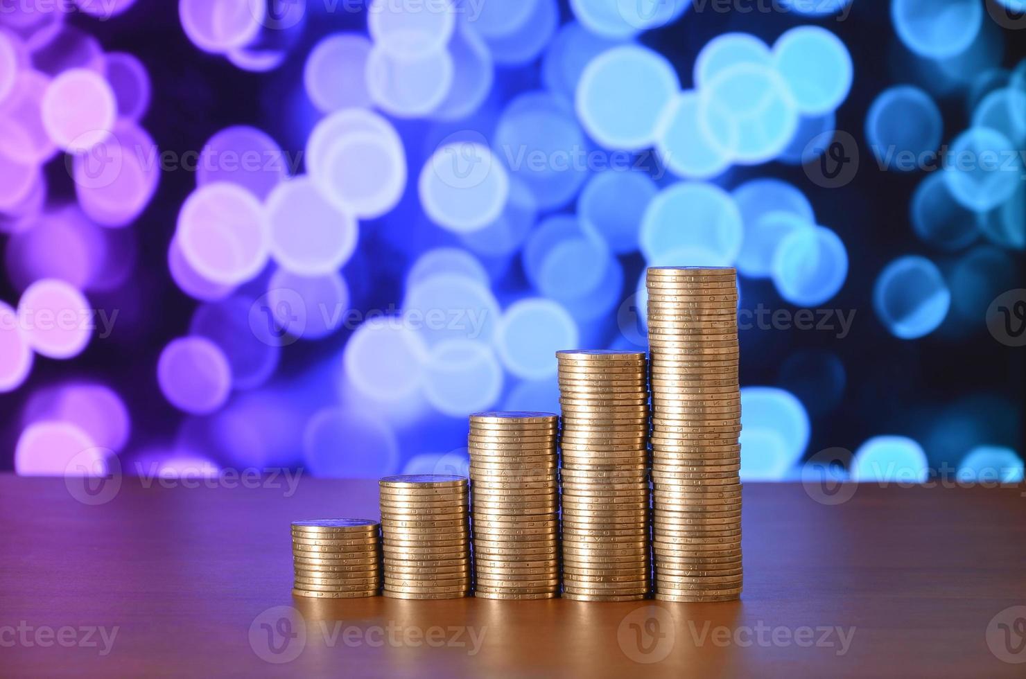 Golden coin stacks arranged as a graph. Increasing columns of coins photo