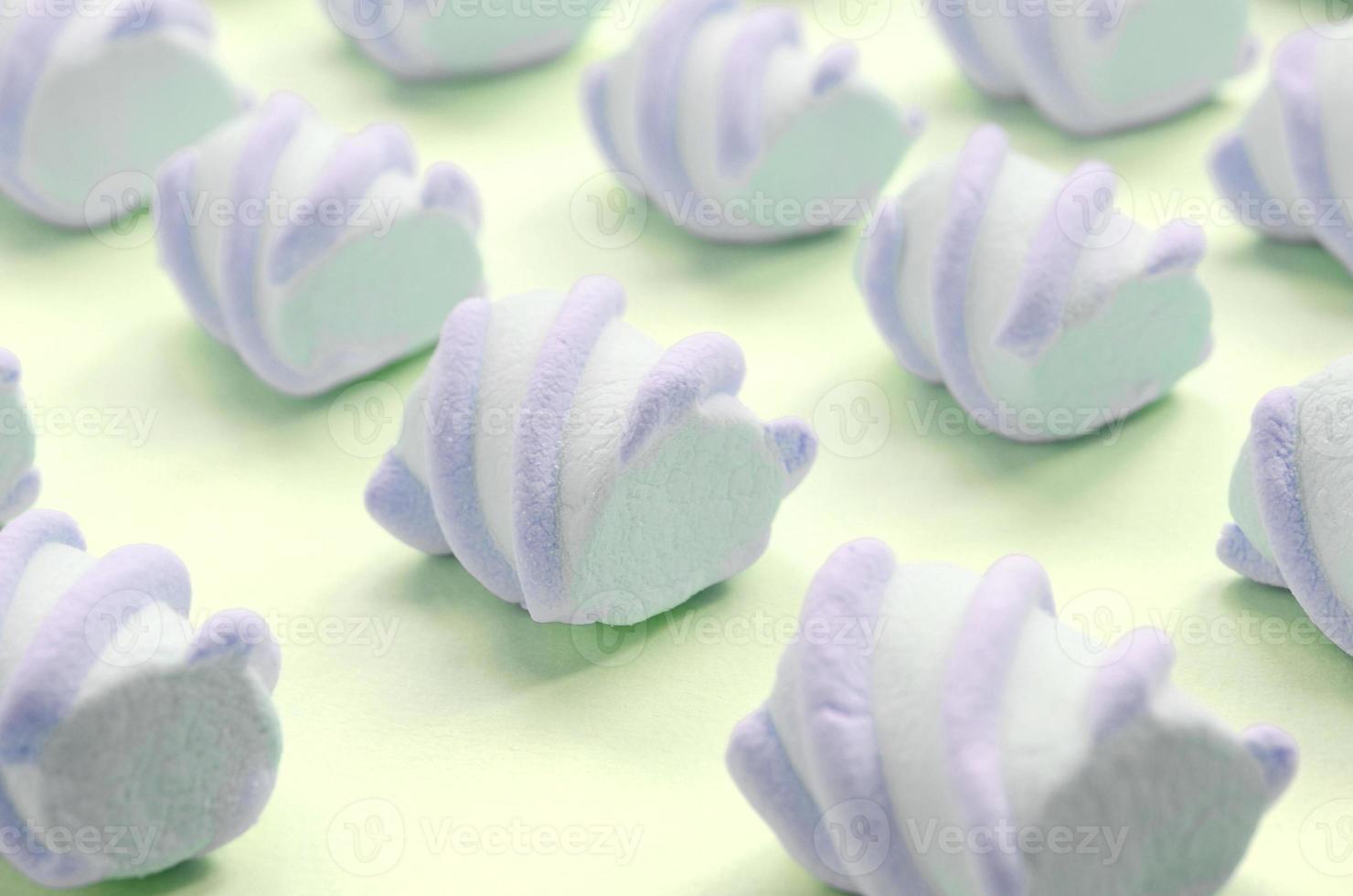 Colorful marshmallow laid out on lime paper background. pastel creative textured pattern photo