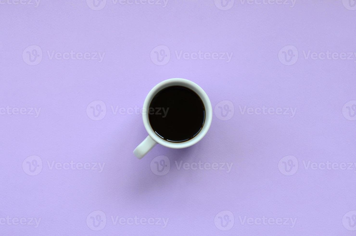 Small white coffee cup on texture background of fashion pastel violet color paper in minimal concept photo