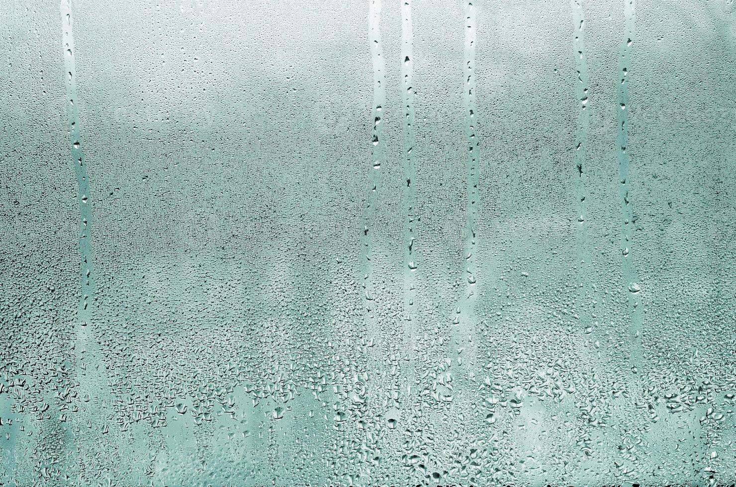 Texture of a drop of rain on a glass wet transparent background. Toned in turquoise color photo