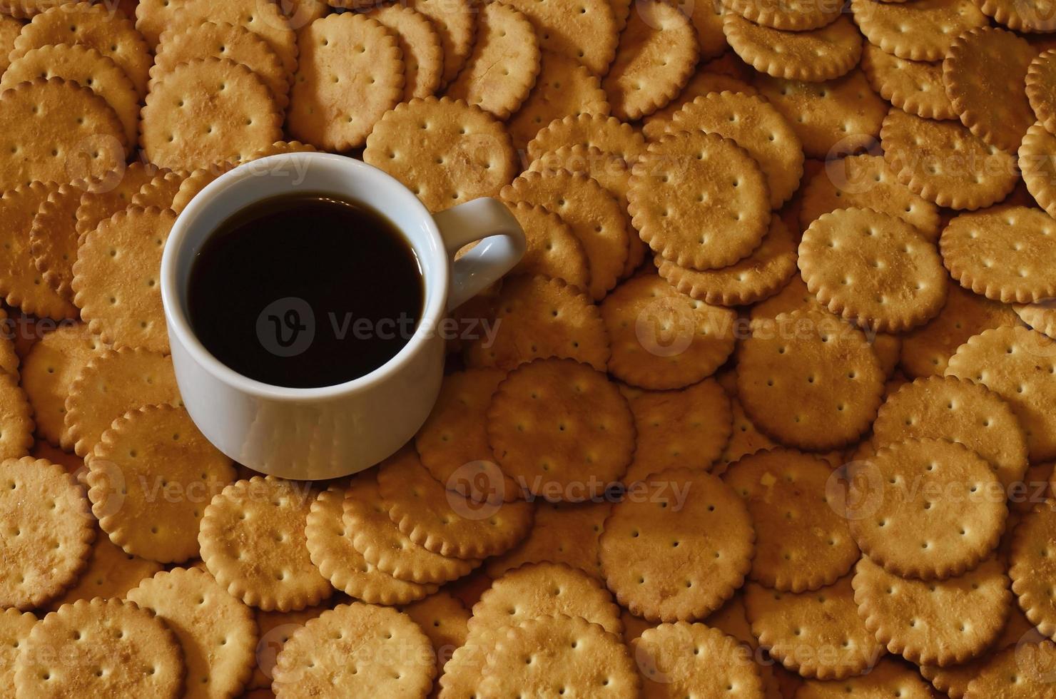 taza de café pequeña y galleta salada foto