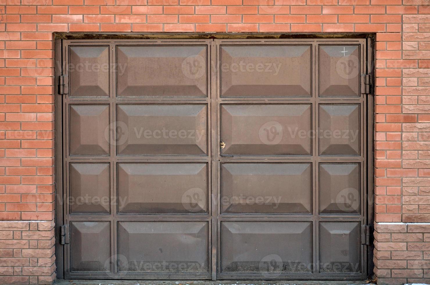 The texture of a painted metal gate from a brick garage photo