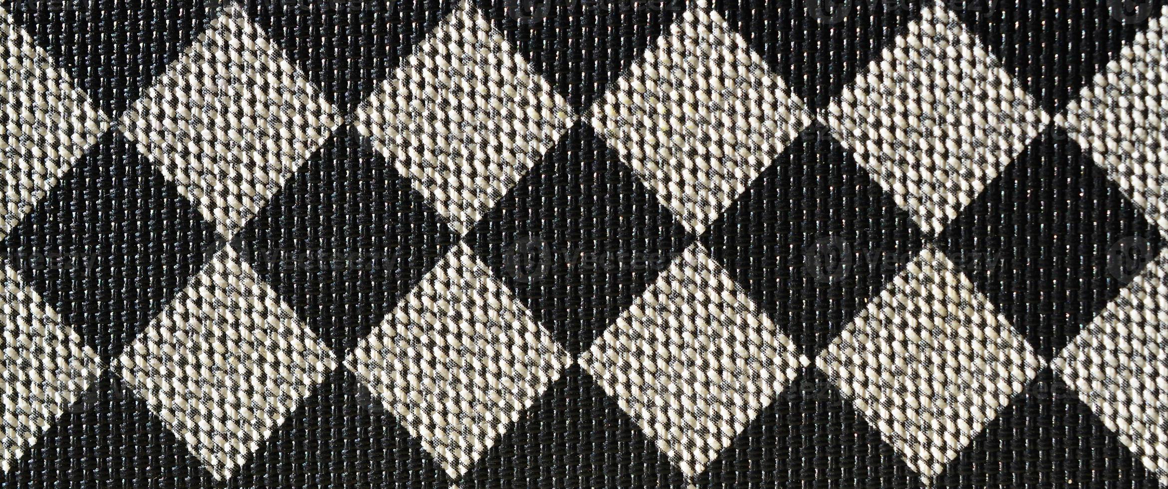 Plastic texture in the form of a very small cloth binding, painted in black and gray in the style of a chessboard. Macro shot photo