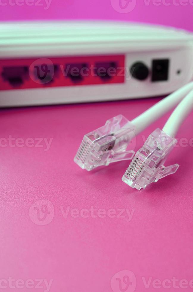 Internet router and Internet cable plugs lie on a bright pink background. Items required for Internet photo