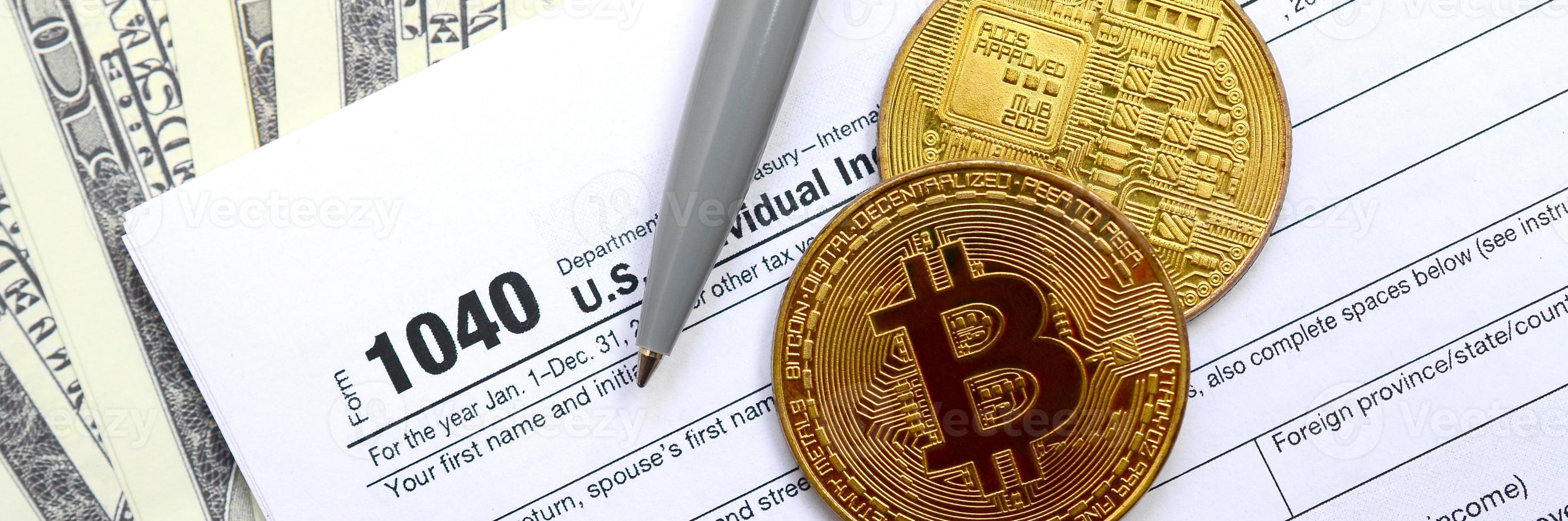 The pen, bitcoins and dollar bills is lies on the tax form 1040 U.S. Individual Income Tax Return. The time to pay taxes photo