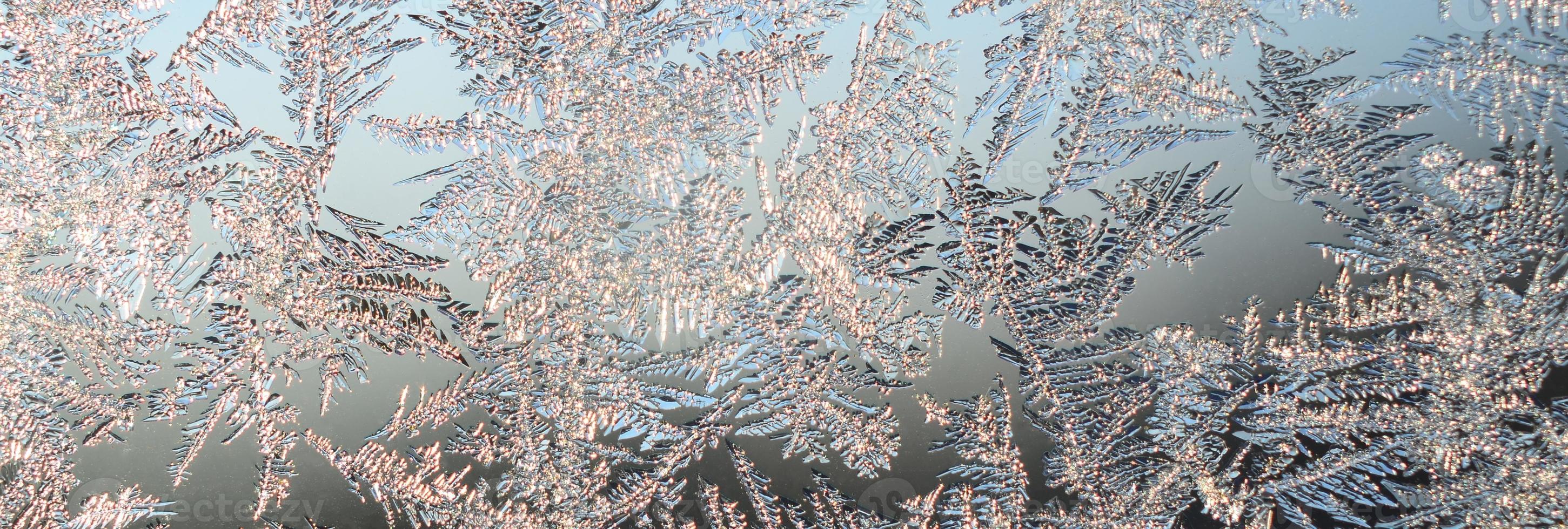 Snowflakes frost rime macro on window glass pane photo