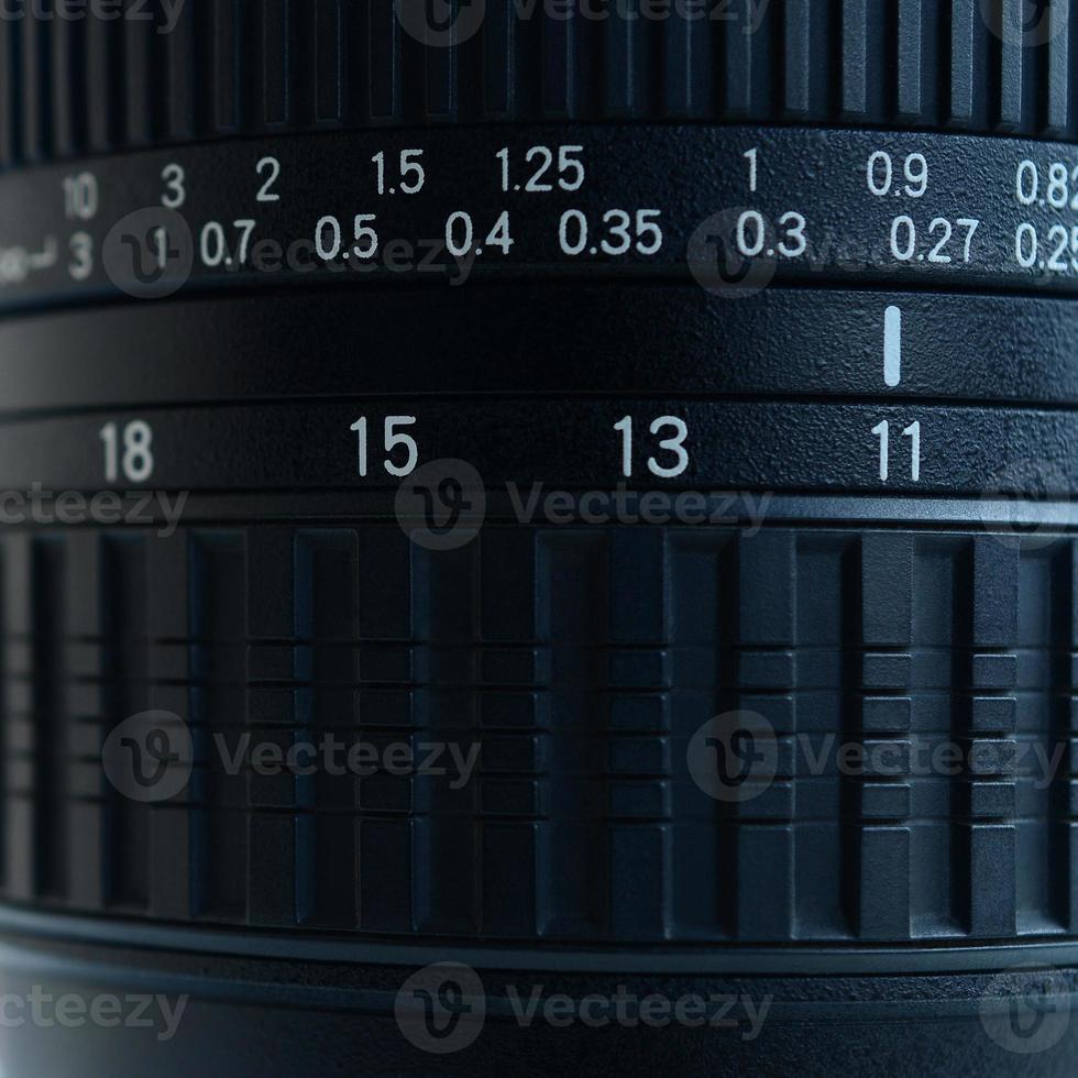 fragmento de una lente de zoom de gran angular para una cámara slr moderna. el conjunto de valores de distancia se indica mediante números blancos en el cuerpo negro foto