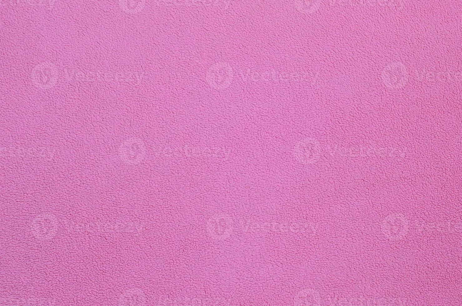 The blanket of furry pink fleece fabric. A background texture of light pink soft plush fleece material photo