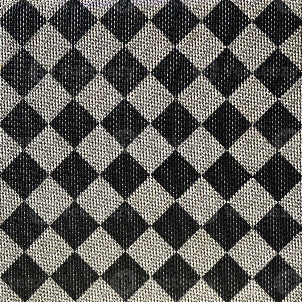 Plastic texture in the form of a very small cloth binding, painted in black and gray in the style of a chessboard. Macro shot photo