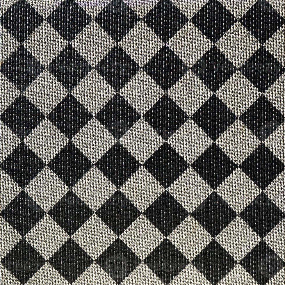 Plastic texture in the form of a very small cloth binding, painted in black and gray in the style of a chessboard. Macro shot photo
