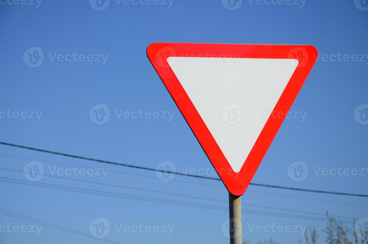 Traffic sign in the form of a white triangle. Give way photo