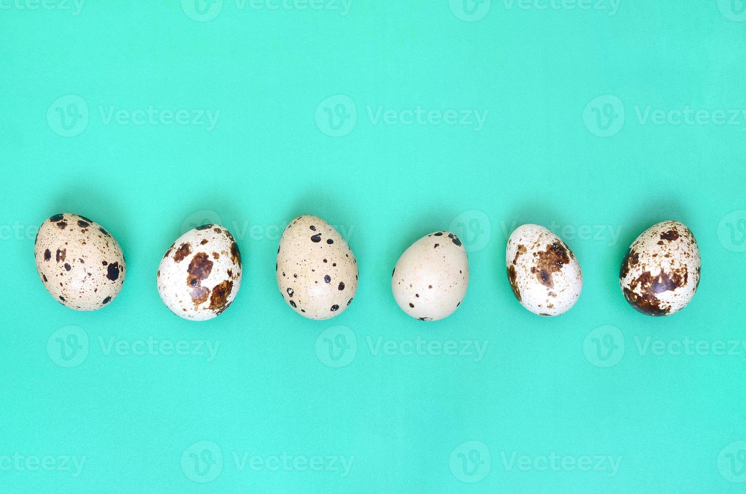 Quail eggs on a light green surface, top view, empty place for text, recipe photo