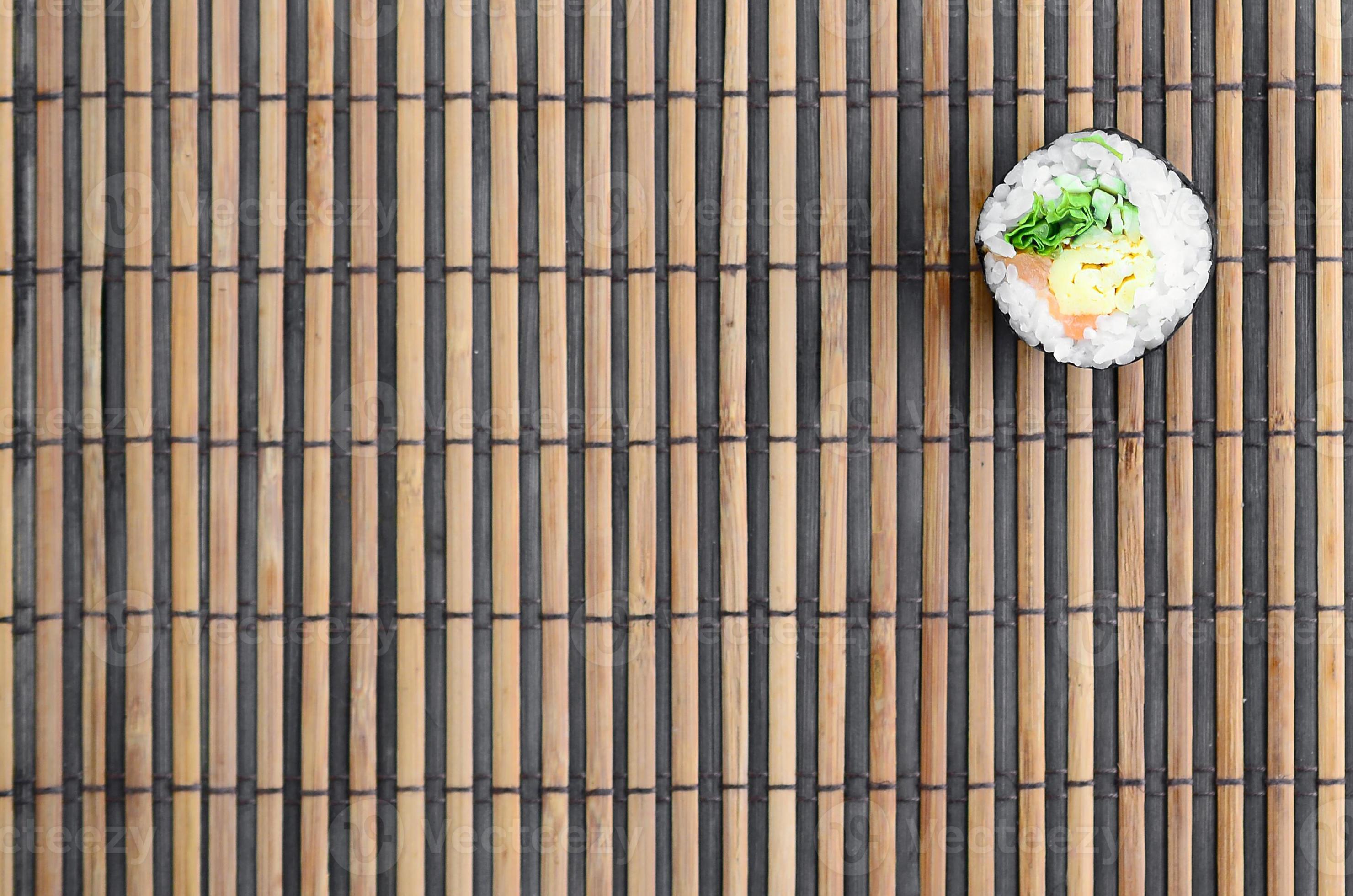 Sushi roll lie on a bamboo straw serwing mat. Traditional Asian food