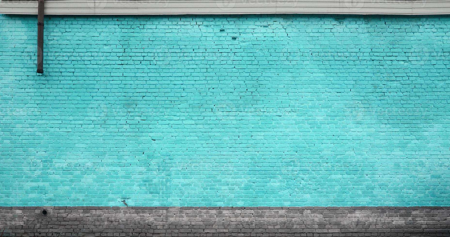 The texture of the brick wall of many rows of bricks painted in cyan color photo