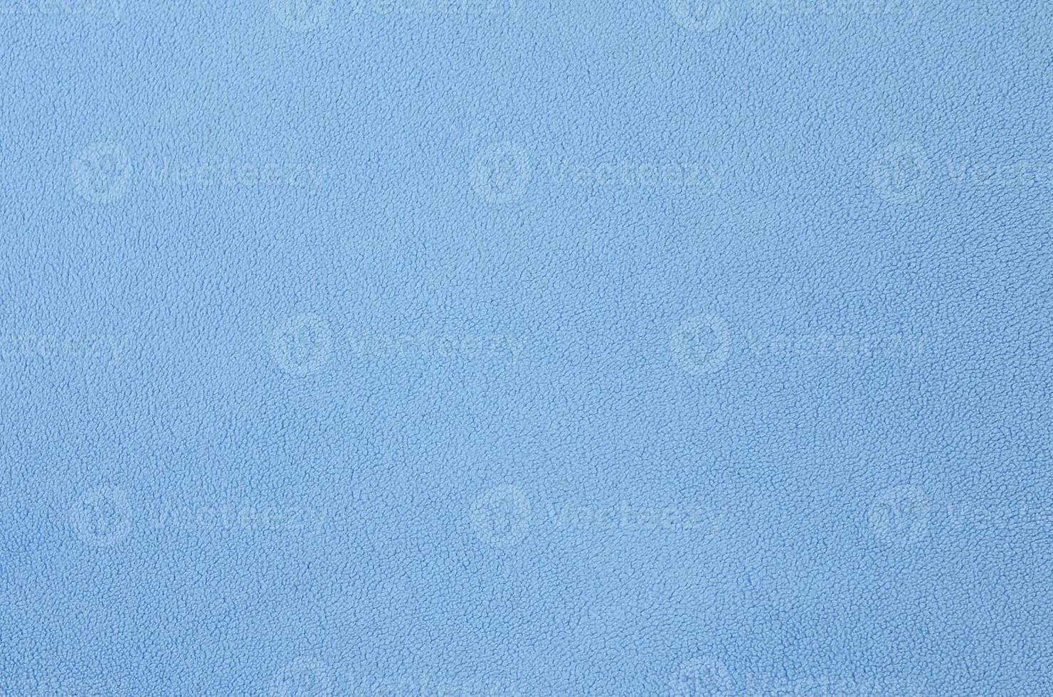 The blanket of furry blue fleece fabric. A background texture of light blue soft plush fleece material photo
