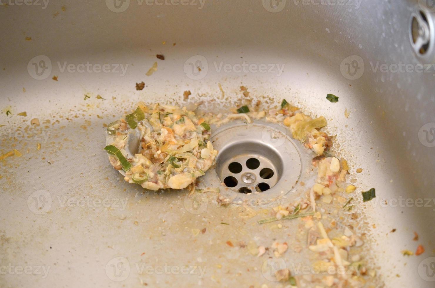 cerrar el desagüe sucio del fregadero de la cocina con partículas de comida foto
