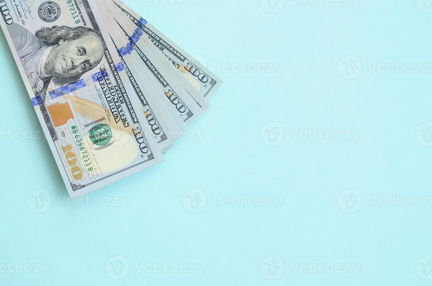 los billetes de dólar estadounidense de un nuevo diseño con una franja azul en el medio se encuentran sobre un fondo azul claro foto