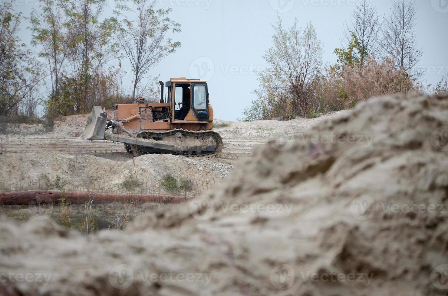 Quarry aggregate with heavy duty machinery. Caterpillar loader Excavator with backhoe driving to construction site quarry photo