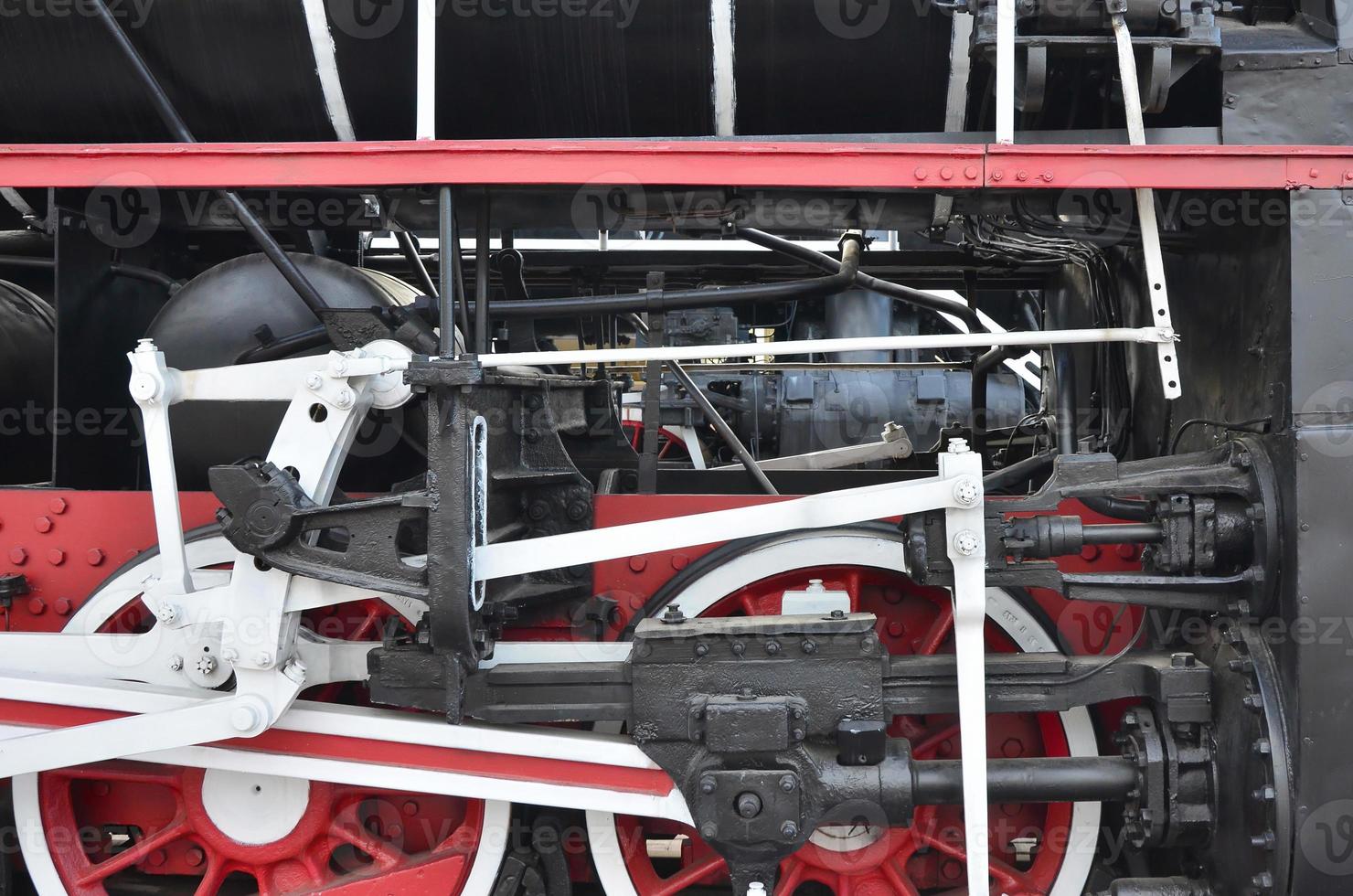 Wheels of the old black steam locomotive of Soviet times. The side of the locomotive with elements of the rotating technology of old trains photo