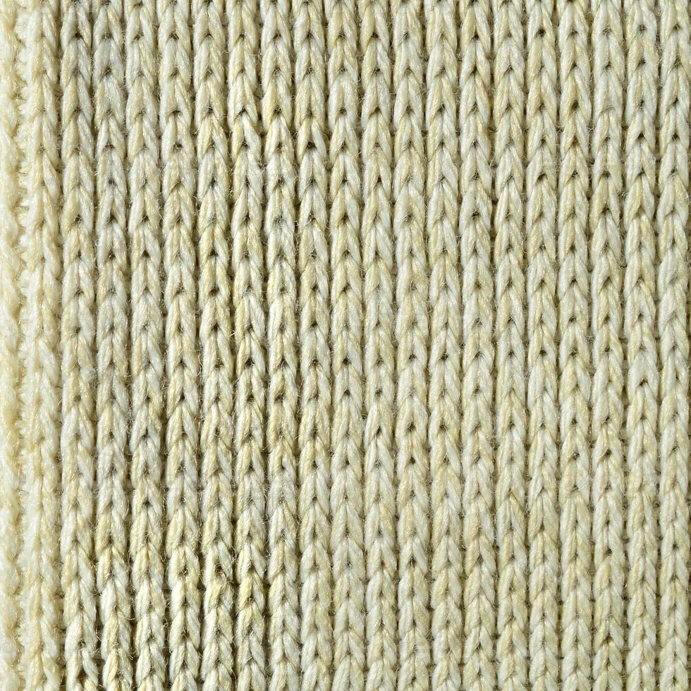 Fabric texture of a soft yellow knitted sweater. Macro image of the structure of bindings in yarns photo