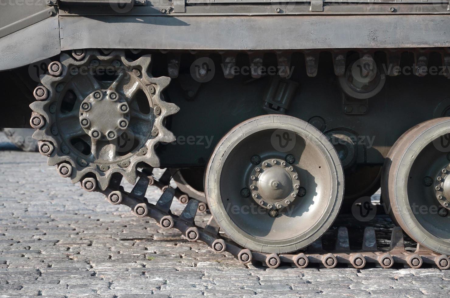 Close up of green armoured caterpillar transport. Modern military transportation vehicle technologies photo