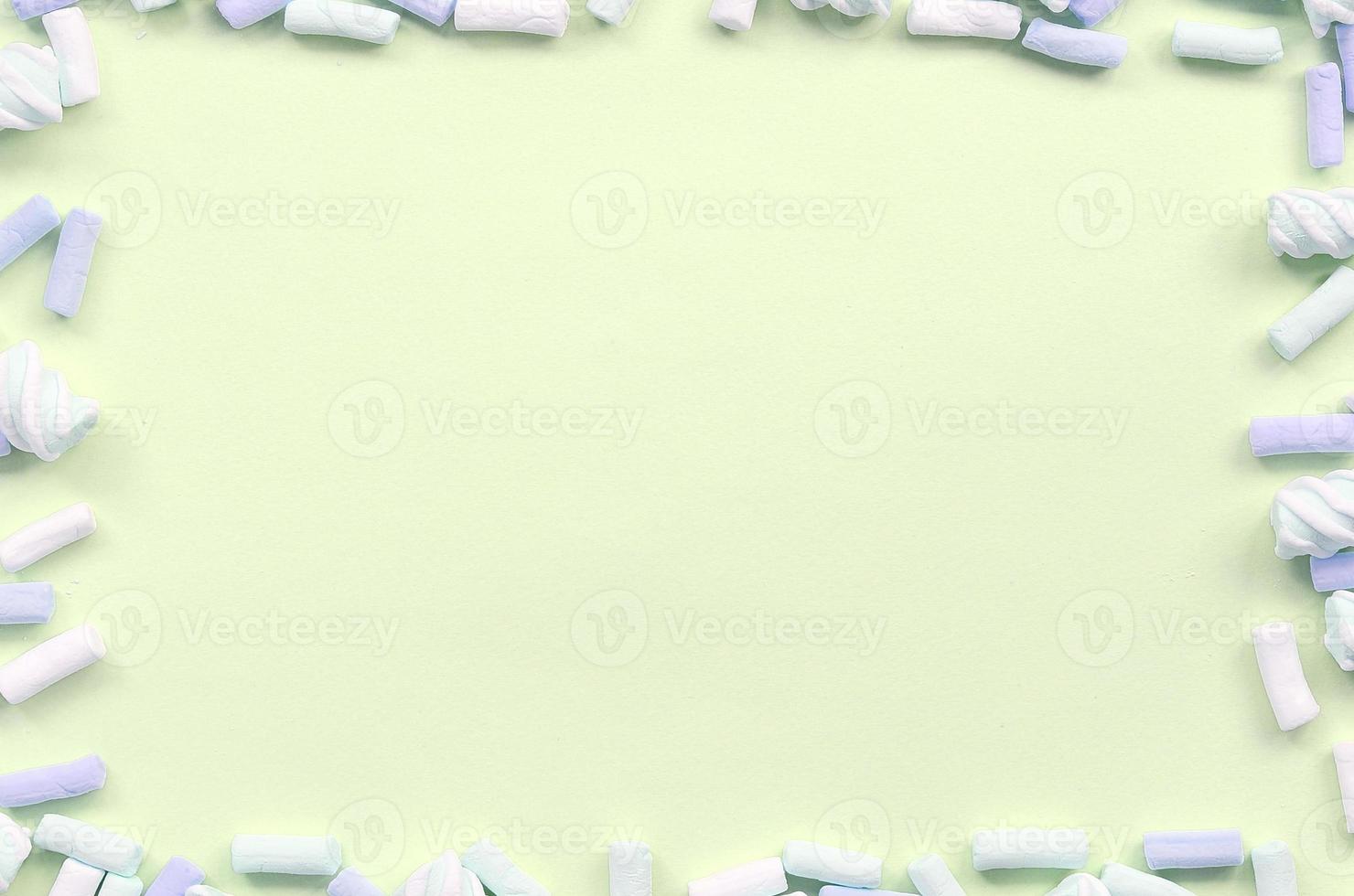 Colorful marshmallow laid out on lime paper background. pastel creative textured framework photo