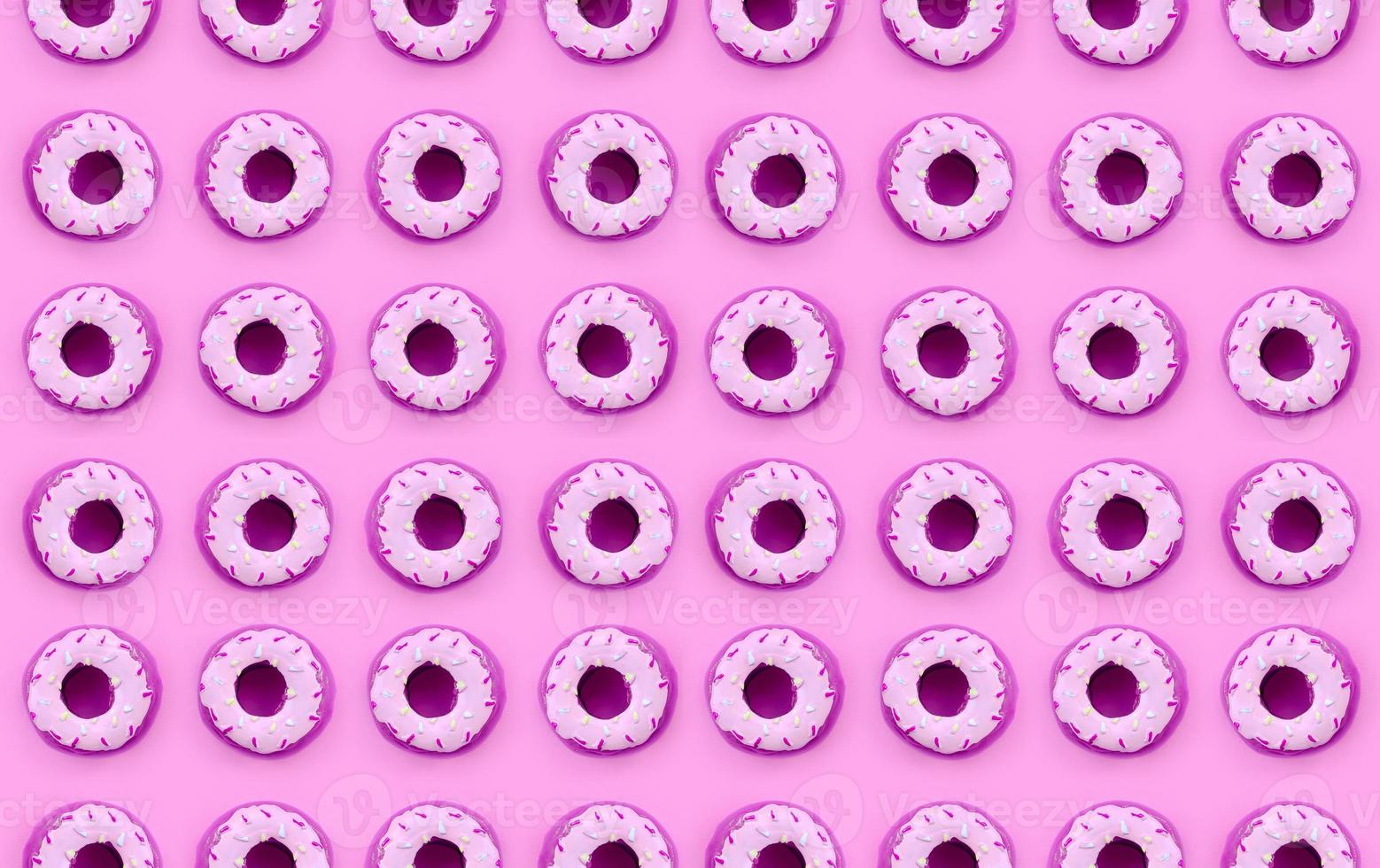 Many small plastic donuts lies on a pastel colorful background. Flat lay minimal pattern. Top view photo