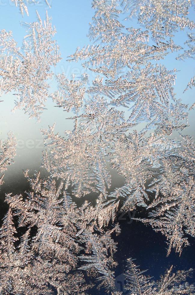 Snowflakes frost rime macro on window glass pane photo