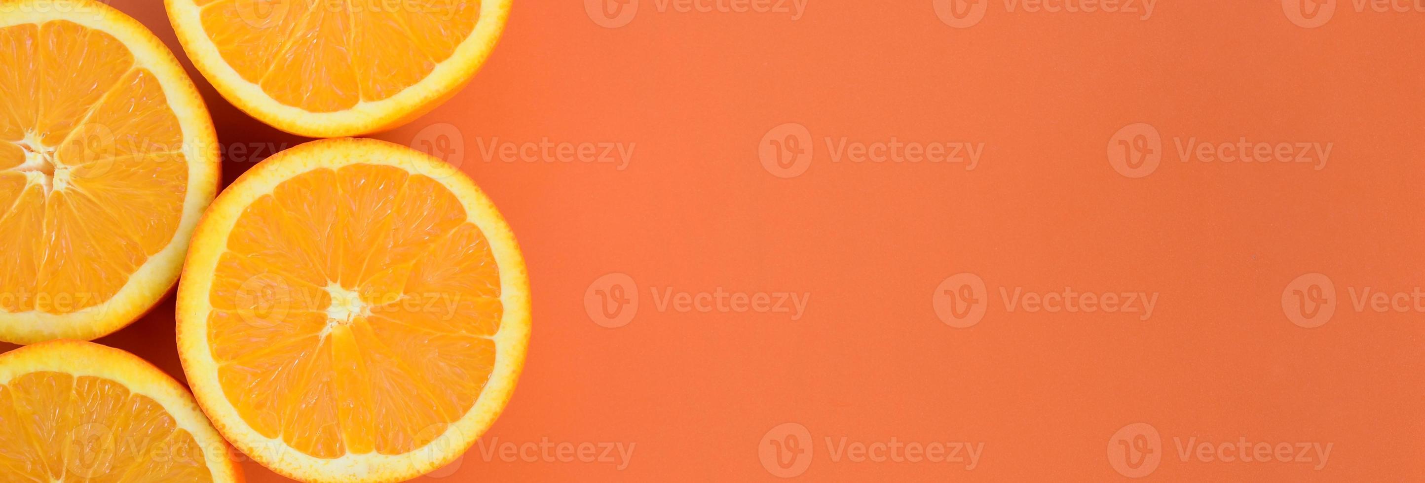 Top view of a several orange fruit slices on bright background in orange color. A saturated citrus texture image photo
