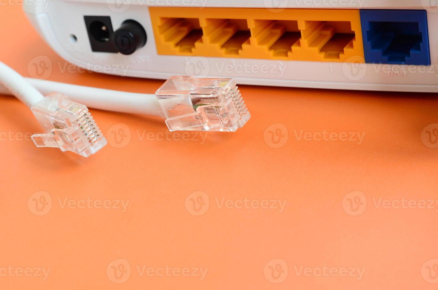 Internet router and Internet cable plugs lie on a bright orange background. Items required for Internet connection photo