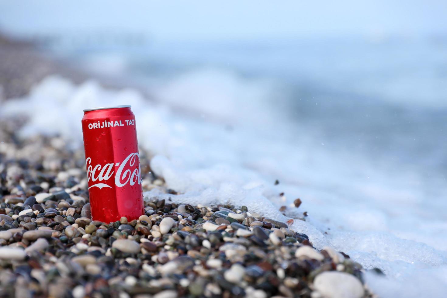 ANTALYA, TURKEY - MAY 18, 2021 Original Coca Cola red tin can lies on small round pebble stones close to sea shore. Coca-cola on turkish beach photo