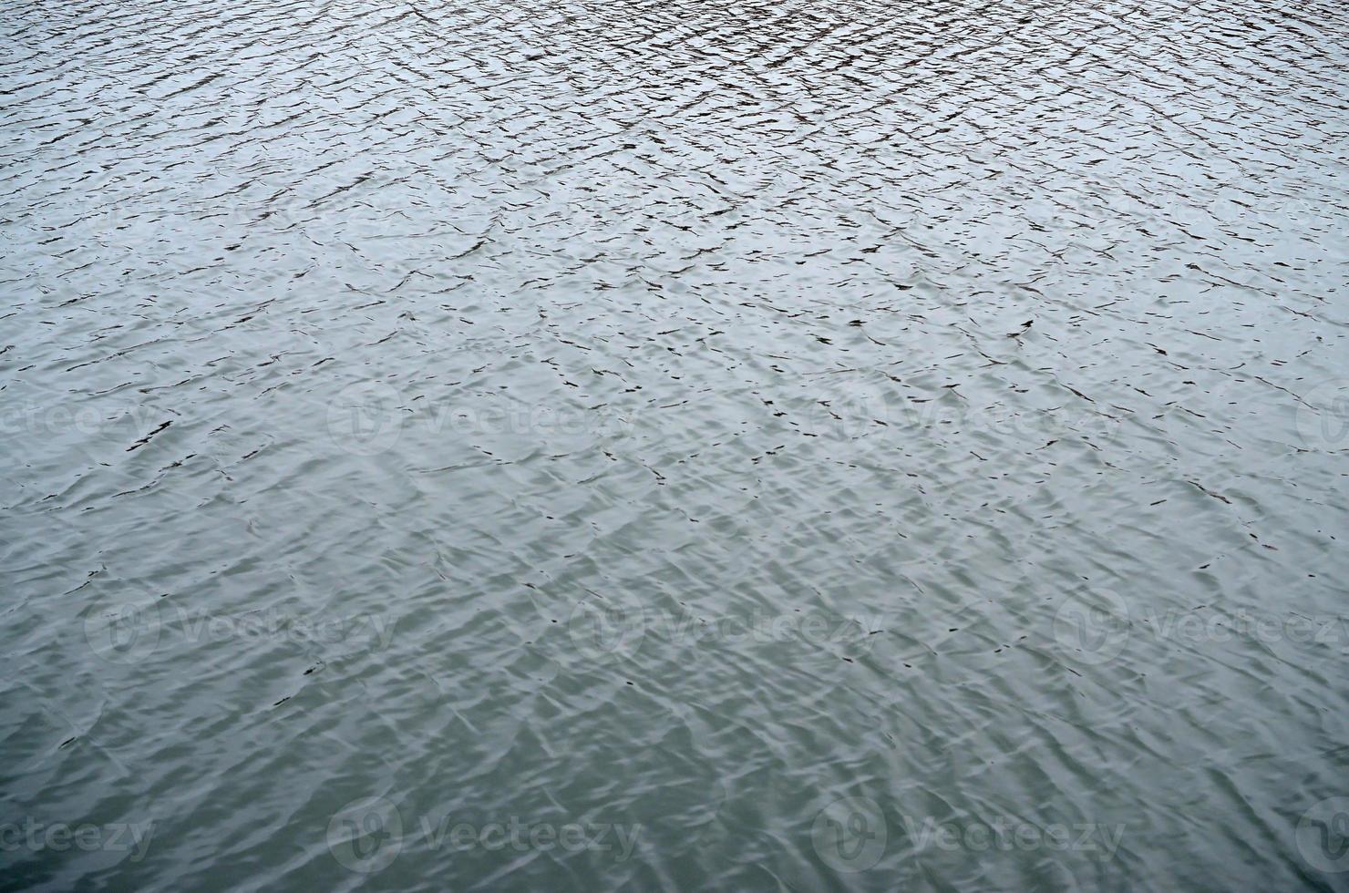 The texture of the water in the river under the influence of wind. A lot of shallow waves on the water surface photo