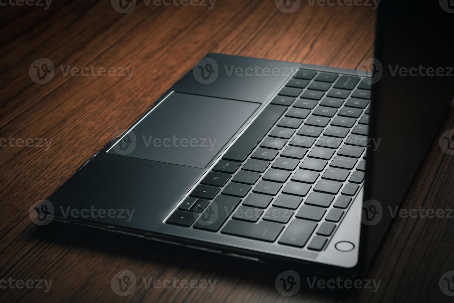 Closeup image of wood desk with modern laptop. Business and finance concept. Technology keyboard with copy space. photo