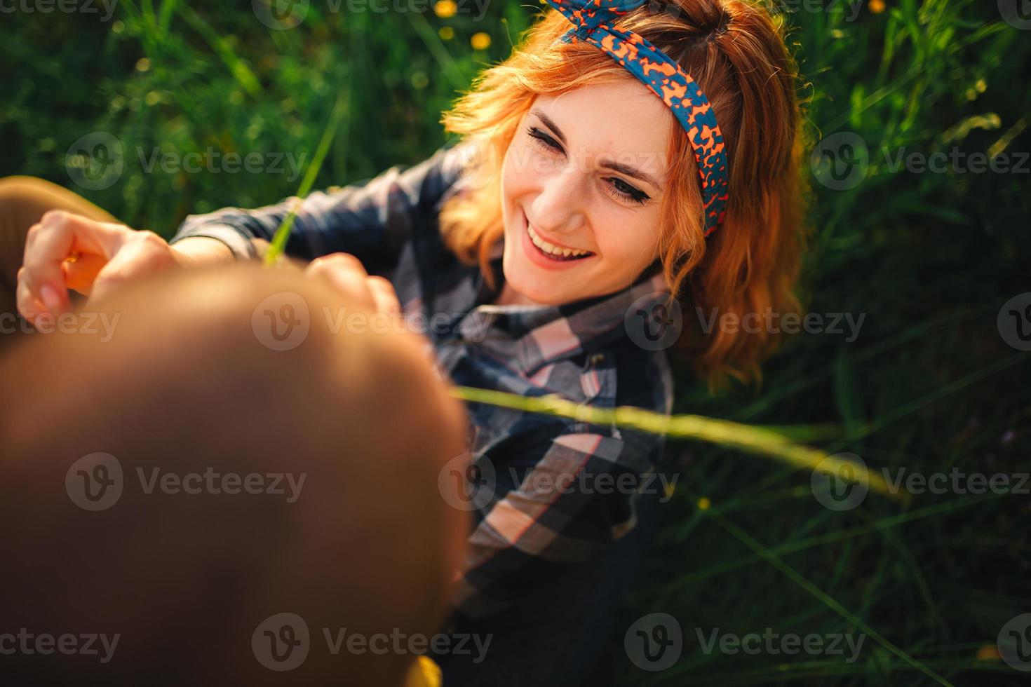 Loving hipster couple walking in the field, kissing and holding hands, hugging, lying in the grass in the summer at sunset. valentines day photo