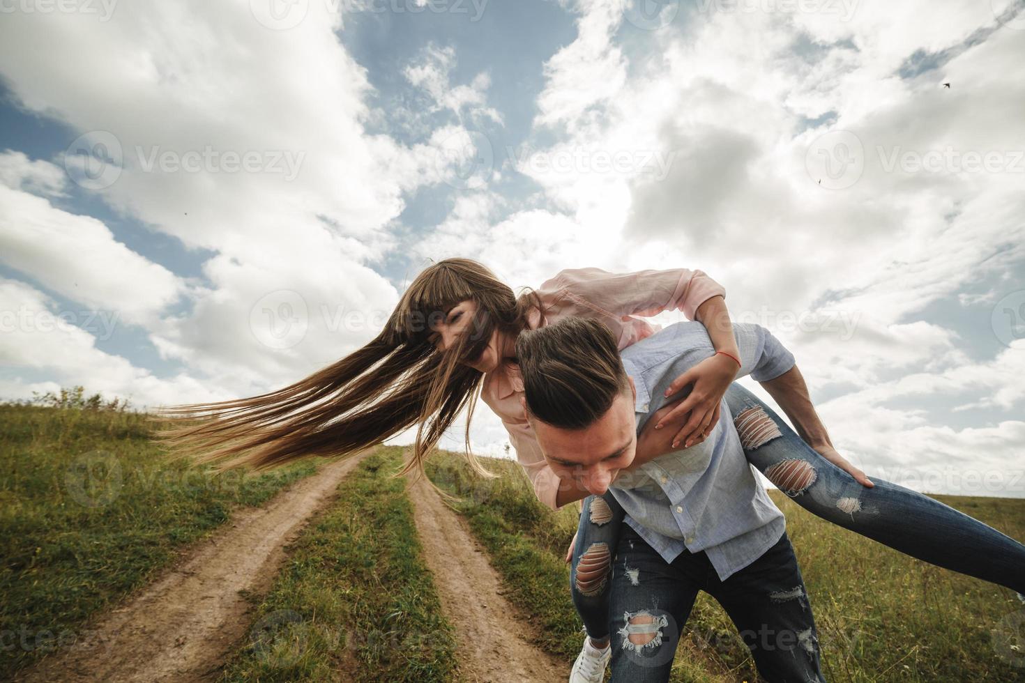 Pareja joven loca divirtiéndose emocionalmente, besándose y abrazándose al aire libre. amor y ternura, romance, familia, emociones, diversión. divirtiéndonos juntos foto