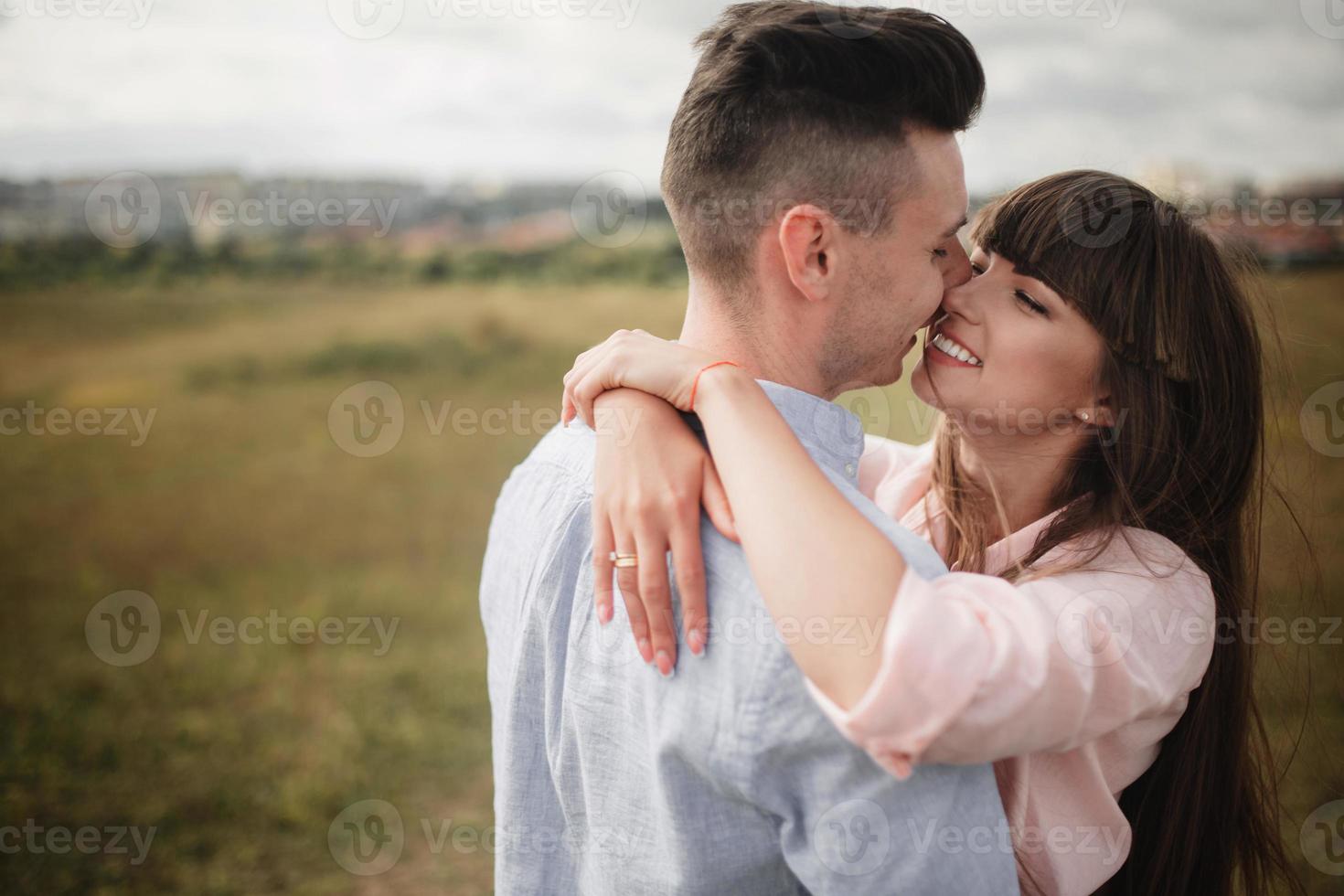 amorosa pareja joven besándose y abrazándose al aire libre. amor y ternura, citas, romance, familia, concepto de aniversario. foto